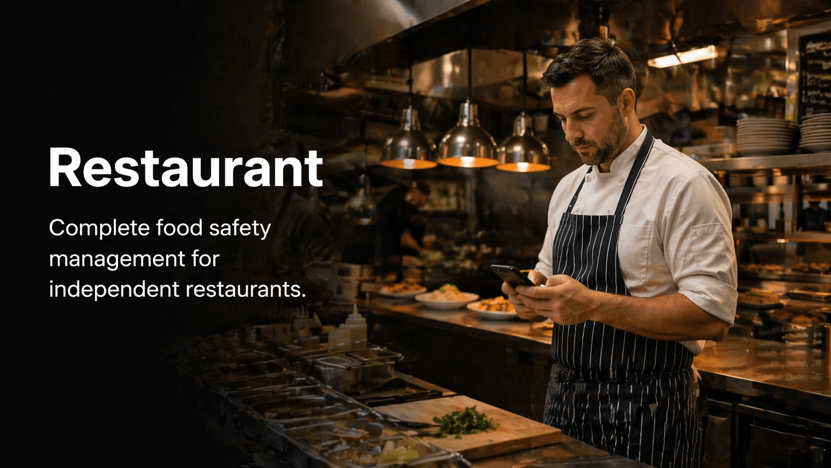Restaurant chef or kitchen manager checking a phone or tablet during prep.